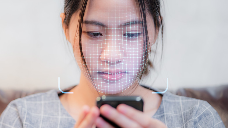 Woman using a face unlock feature as it scans a 3d model of her face