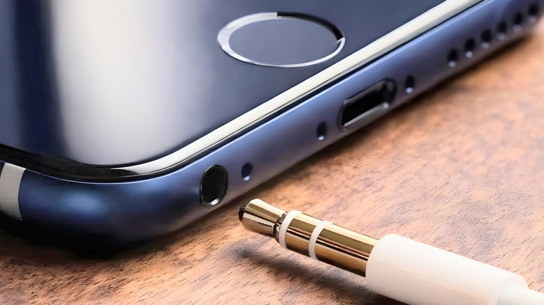 Aux cord being plugged into the headphone jack on an iPhone