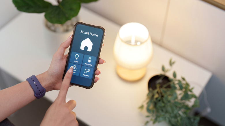 A person controlling a light with a smart home app.