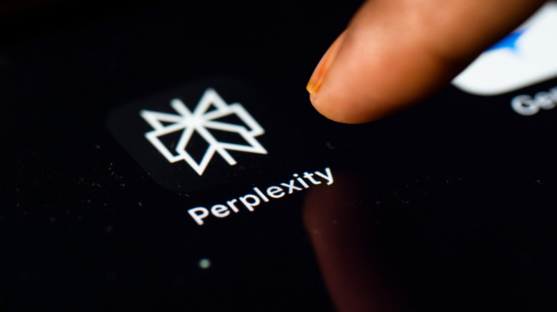 In this photo Illustration a person browsing taps perplexity app icon on a tablet device