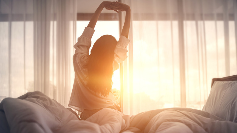 Person waking up with sunlight streaming in through window