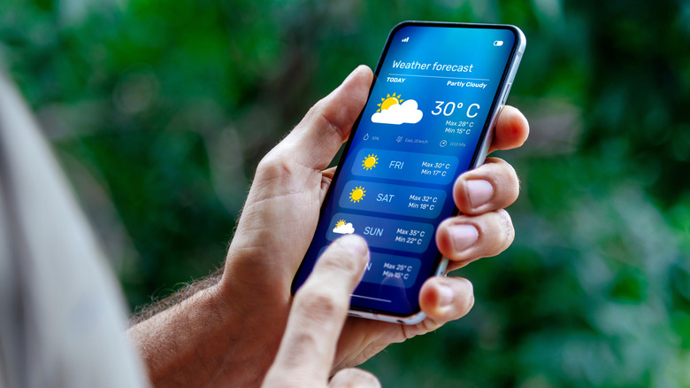 a man looking at the weather app on his phone