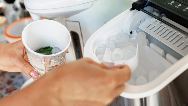 A woman scooping out ice from an ice maker