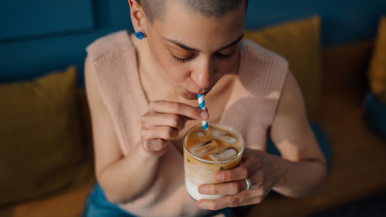 a woman drinking iced coffee