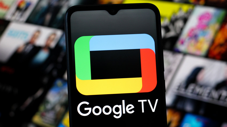 the Google TV logo on a smartphone with shows on a screen behind it