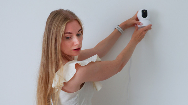 Woman installing a security camera herself
