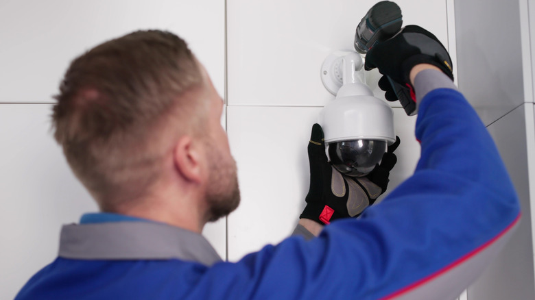 Professional installing a camera for a security system