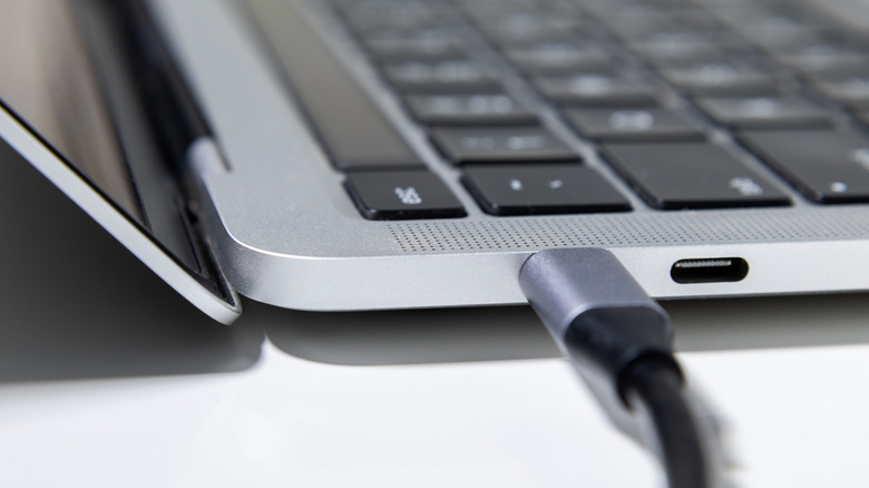 Close up of a USB-C cable plugged into the side of a laptop.