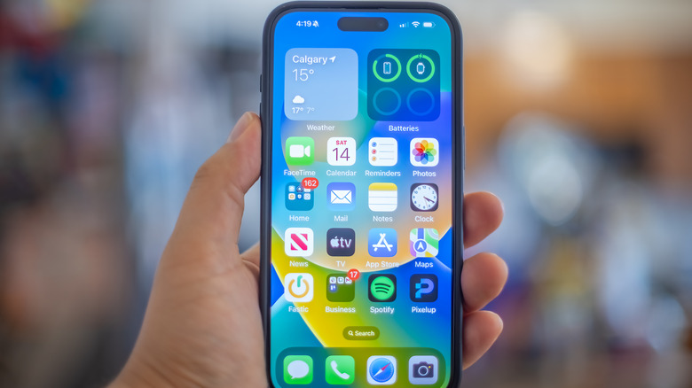 An iPhone 15 Pro in hand, connected to Wi-Fi and Cellular networks.