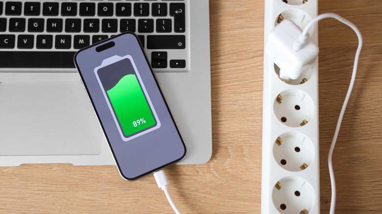 Phone on laptop connected to charger nearby