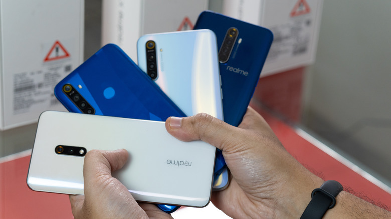 Hands holding budget Android phones