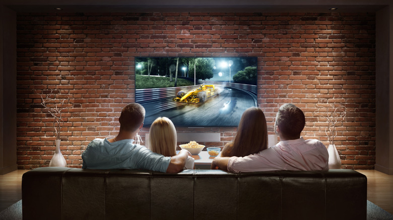 Four people sat watching TV