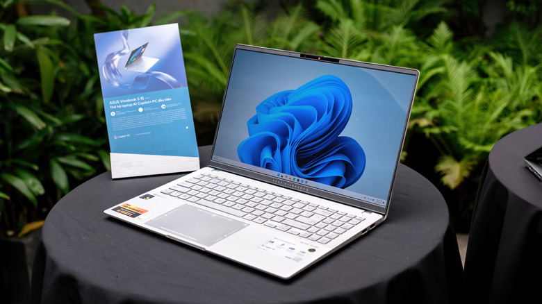An Asus Vivobook laptop with an OLED display on a table.