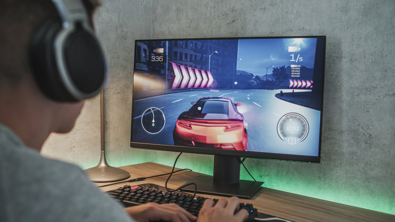 Person playing a PC racing game on a monitor