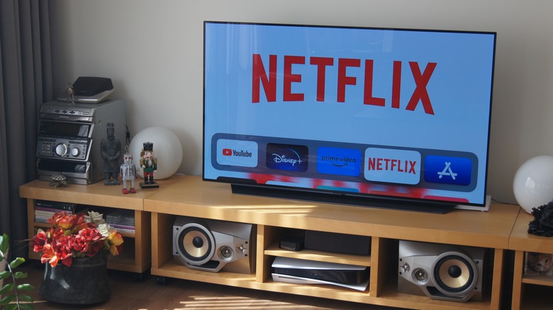 Smart TV on a living room stand displaying the Netflix home screen
