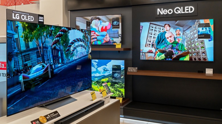 OLED and QLED TVs displayed side by side in an electronics store