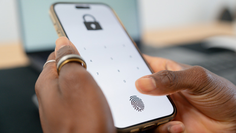 Close up of person using a fingerprint scanner for security on their smartphone.