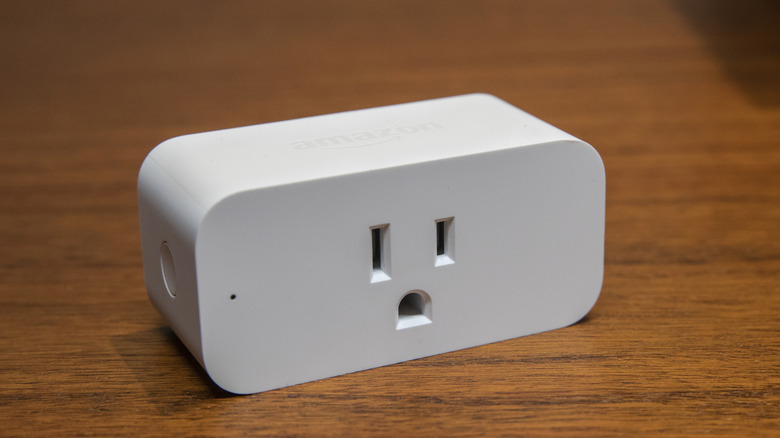 An Amazon-branded smart plug on a wooden table.