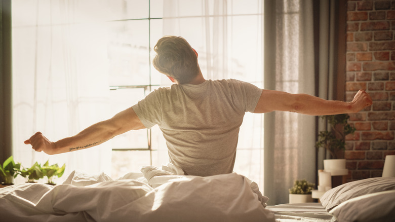 A man stretching as he wakes up in the morning