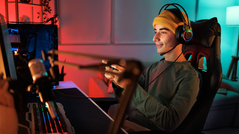 a man with a headset playing a game in a dark room