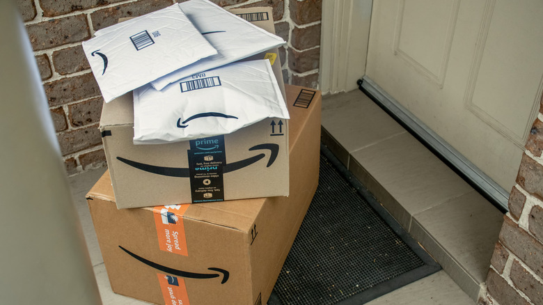 Pile of Amazon shipment boxes outside a house door