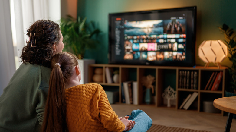a mother and daughter watching movies at home