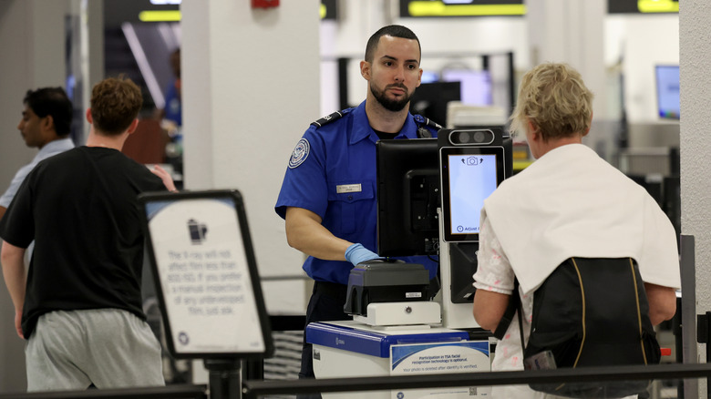 A TSA agent checking a man into security at the airport.