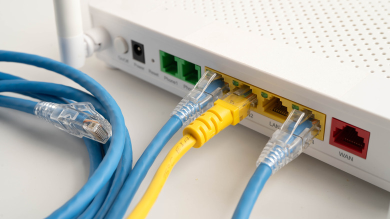 Close-up of the back of a router showing WAN and LAN ports with cables connected.