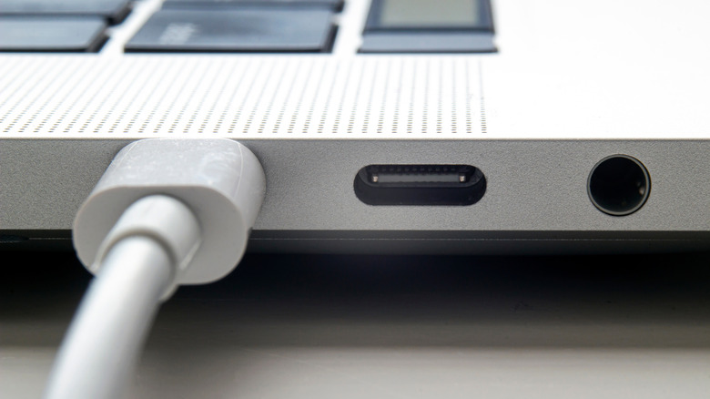 Close up of macbook port with a usb-c/thunderbolt cable plugged in