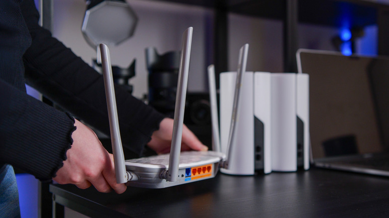 A person setting up a Wi-Fi mesh system