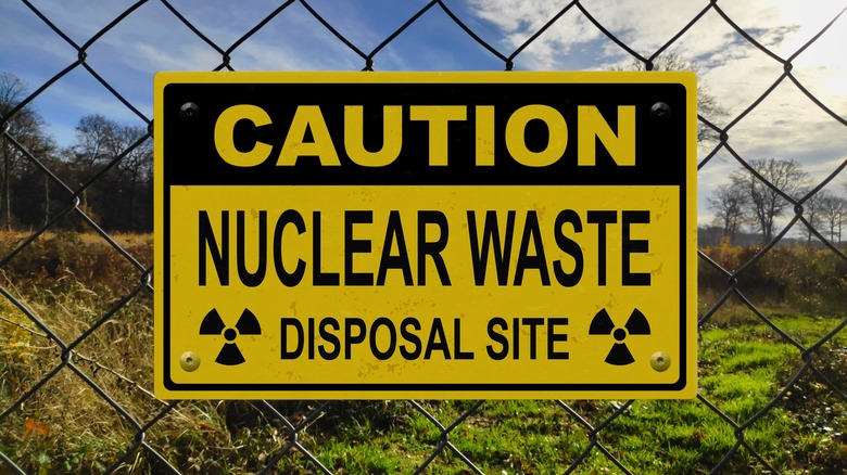 a caution: nuclear waste disposal site warning sign on a fence
