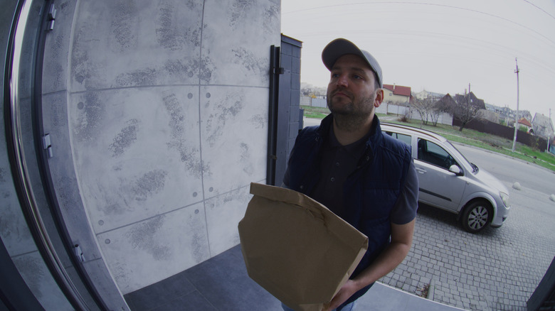 a delivery man being watched on a Ring doorbell camera