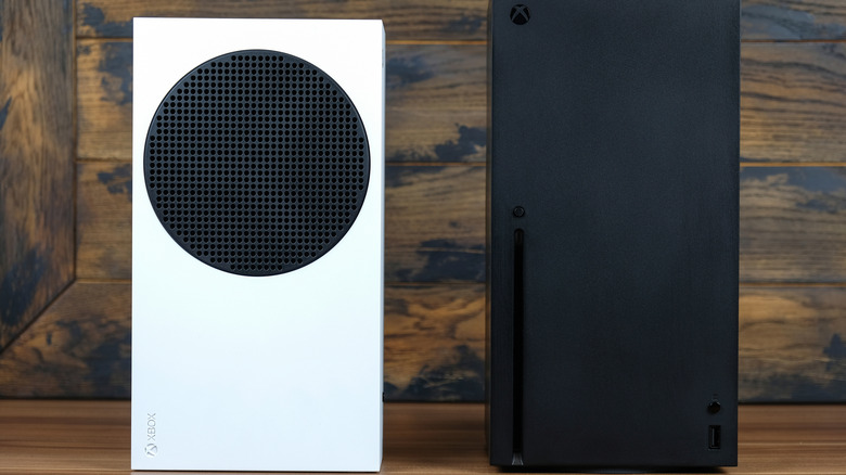 A white and black Xbox Series X standing upright on a wooden surface.