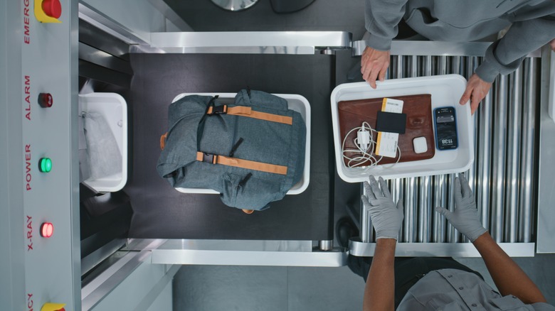 Items being loaded through a TSA scanner.