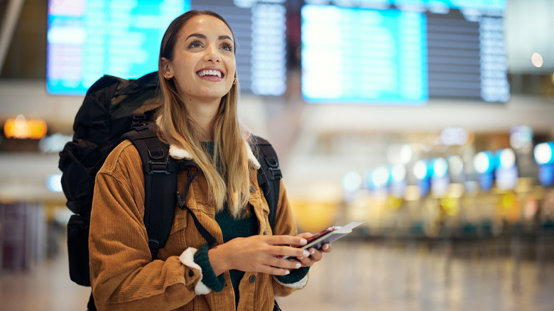 Woman preparing to travel with pack and ID documents.