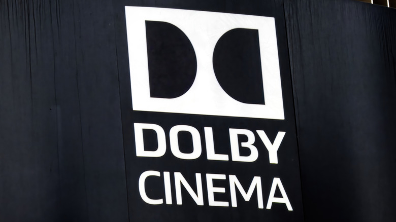 A Dolby Cinema logo embossed on a black cinema curtain.