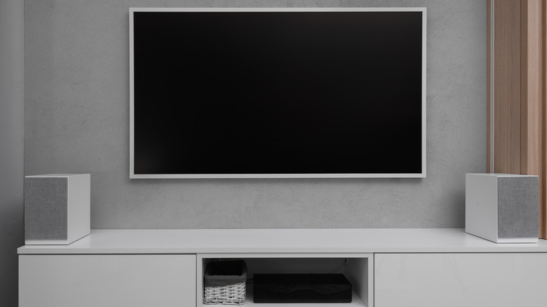 A home theater setup with a TV, receiver, and two speakers visible