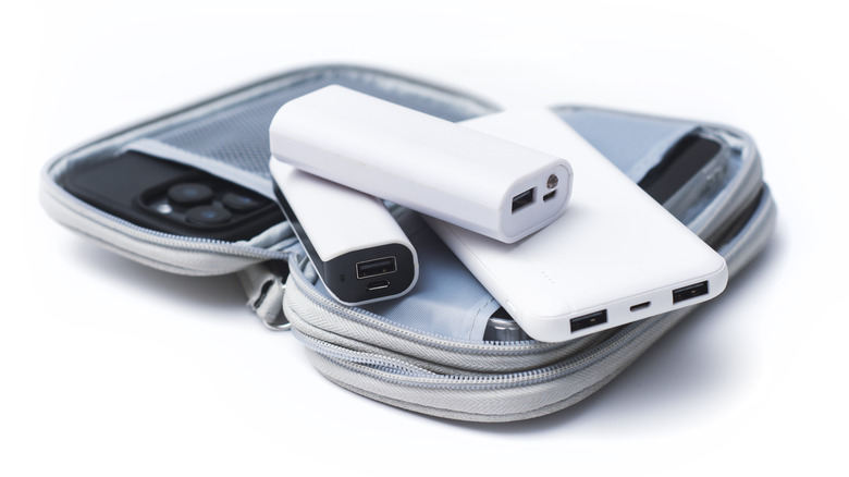 Various white USB-powered devices placed atop a light gray zipper pouch against a white background
