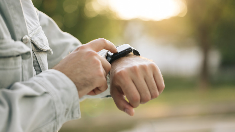A close-up of hands using an Apple Watch