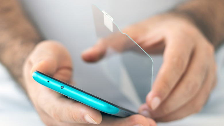 Hand applying phone screen protector