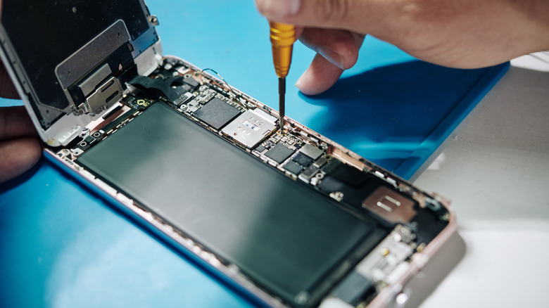 Technician working on a smartphone that has the case removed.