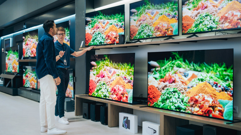 Person in an electronics store shopping for a new TV
