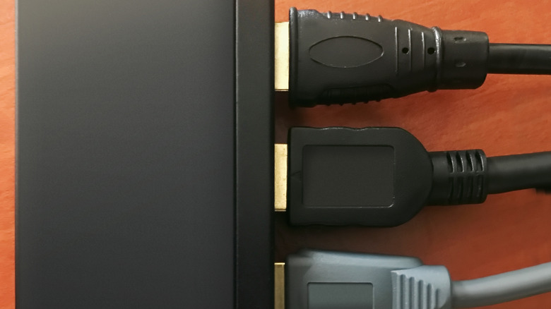 Multiple HDMI cables plugged into the back of a switch.