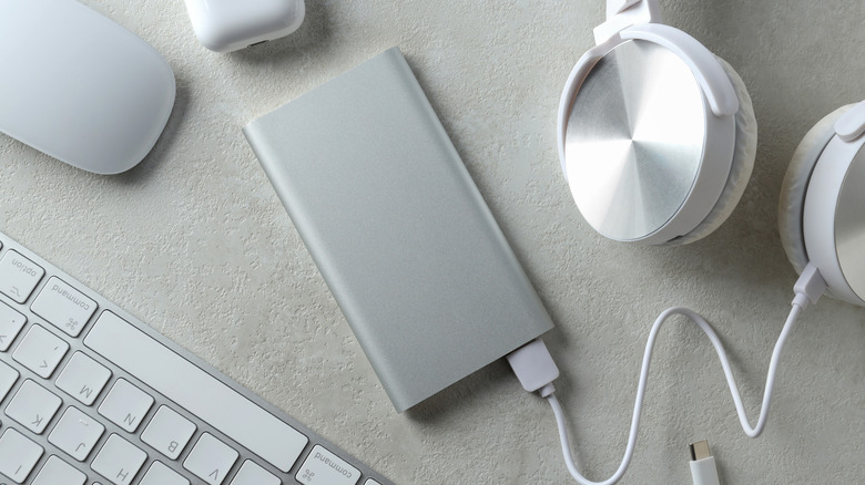 Power bank with headphones and peripherals on a desk.