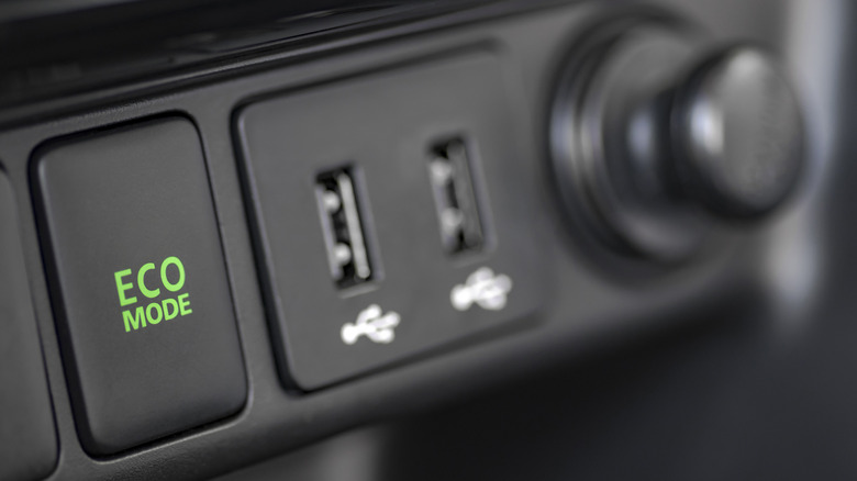 Close up of USB ports on vehicle dash with eco mode button visible.