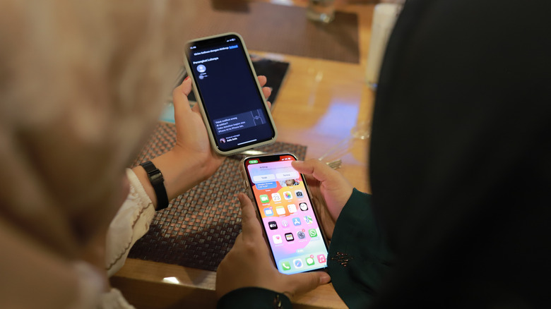 Two people sharing files between iPhones using AirDrop