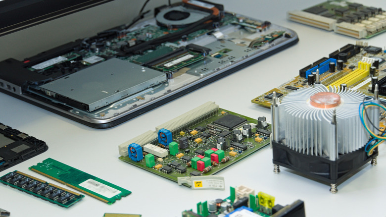 Laptop repair underway with hardware components placed on a table