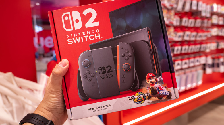 Someone holding up a Nintendo Switch 2 + "Mario Kart Word" bundle