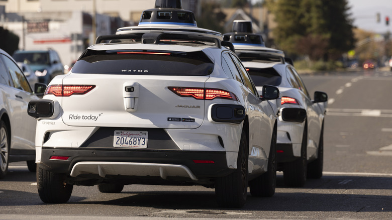 Two Waymo vehicles at a stoplight