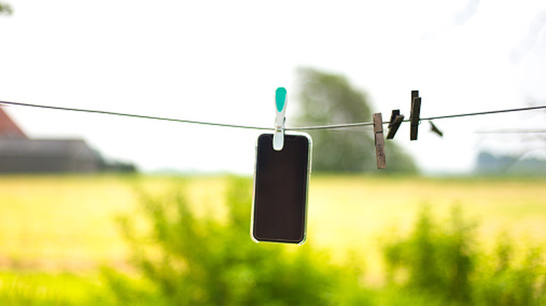 Smartphone hanging out to dry on an outdoor laundry line.